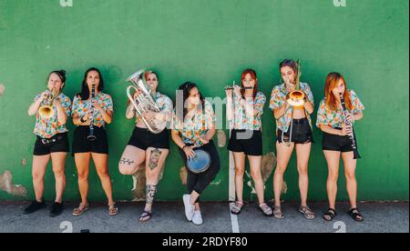 Groupe de musique folklorique féminin debout devant le mur Banque D'Images