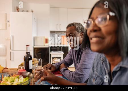 Heureux homme senior appréciant le dîner avec des amis à la maison Banque D'Images