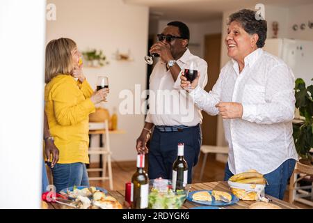 Homme heureux s'amusant avec des amis au dîner à la maison Banque D'Images