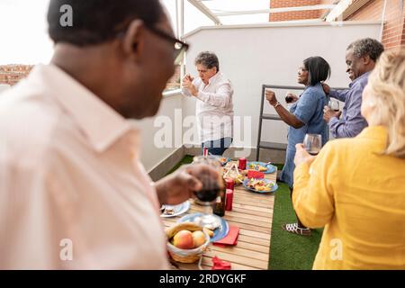 Heureux amis seniors dansant sur le balcon Banque D'Images