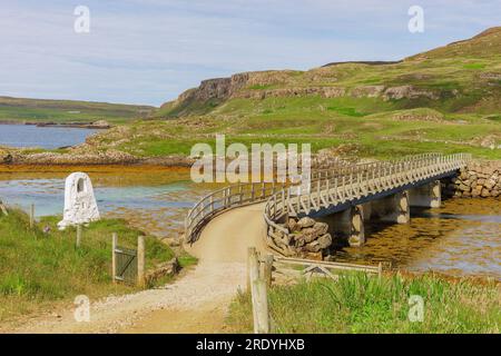 Le nouveau pont qui relie l'île de Canna à Sanday sur une étendue d'eau avec monument blanc et chemin menant à Traigh Bhan, un bea blanc et sablonneux Banque D'Images