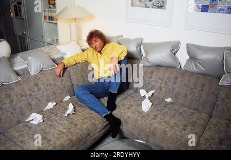 Bernhard Brink, deutscher Schlagersänger, leidet auf dem Sofa in Berlin an Männergrippe, Deutschland 1996. Banque D'Images