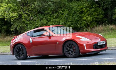 Milton Keynes, Royaume-Uni - 21 juillet 2023 : 2015 rouge Nissan 370Z voiture conduisant sur une route anglaise Banque D'Images