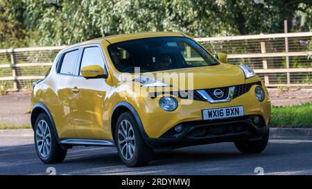 Milton Keynes, Royaume-Uni - 23 juillet 2023 : 2016 jaune Nissan juke voiture conduisant sur une route anglaise Banque D'Images