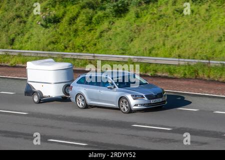 2018 Skoda Superb se L Executive TDI S-A TDI 150 DSG7 SCR Auto Start/Stop Silver car Estate Diesel 1968 cc, remorquage petite caravane de pod voyageant à grande vitesse sur l'autoroute M6 dans le Grand Manchester, Royaume-Uni Banque D'Images