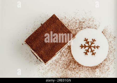 Tiramisu servi avec du chocolat sur une assiette en porcelaine blanche Banque D'Images