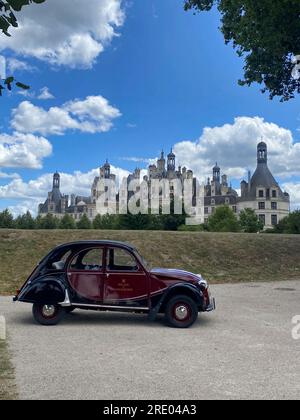 Citroën 2CV avec le château de Chambord en arrière-plan. Vallée de la Loire, France. Banque D'Images