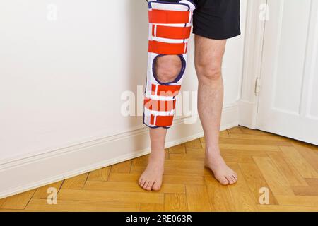 Dispositif réglable d'immobilisation du genou ou d'attelle de jambe sur un patient masculin, utilisé pour la fixation de l'articulation du genou comme traitement en cas de fracture ou de rupture ligamentaire. Banque D'Images