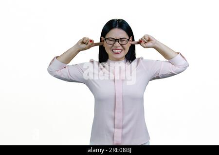 Jeune femme d'affaires asiatique mettant les doigts dans ses oreilles avec les yeux fermés. Elle ne veut pas l'entendre. Isolé sur blanc. Banque D'Images