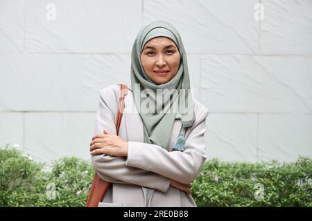 Portrait de femme mûre heureuse portant le hijab au bureau Banque D'Images