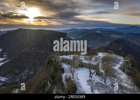 Vue aérienne des falaises de Cabrera et du sanctuaire lors d'un lever de soleil hivernal avec neige à Collsacabra (Osona, Barcelone, Catalogne, Espagne) Banque D'Images