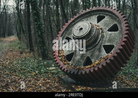 Un vieil énorme équipement rouge inutilisé dans la forêt en automne. Machine d'histoire industrielle. Machines abandonnées. Production de fer et d'acier. Banque D'Images