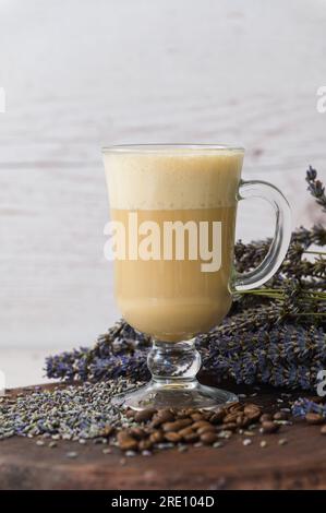 Café raf lavande sur une planche de bois avec de la lavande sèche et des grains de café. Banque D'Images