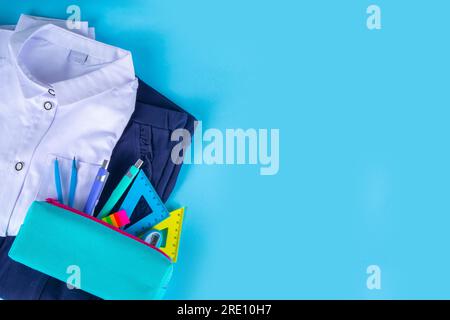 Préparation à l'école, retour à l'école. Uniforme d'élève des enfants d'école, jupe, pantalon, chemise avec étui à crayons, accessoires d'étude sur brigh Banque D'Images