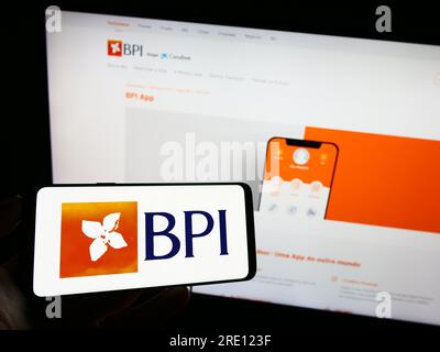 Personne détenant un téléphone portable avec le logo de Banco Portugues de Investimento sa (BPI) sur l'écran devant la page Web de l'entreprise. Concentrez-vous sur l'affichage du téléphone. Banque D'Images