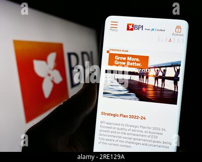 Personne détenant un téléphone portable avec page web de Banco Portugues de Investimento S.A. (BPI) sur l'écran devant le logo. Concentrez-vous sur le centre de l'écran du téléphone. Banque D'Images