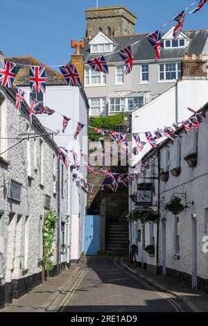 Vue le long de Fore Street Salcombe à côté de la station de bateau de vie RNLI avec Church & Fortescue Pub en vue le long de la route Union Jack Bunting au soleil Banque D'Images