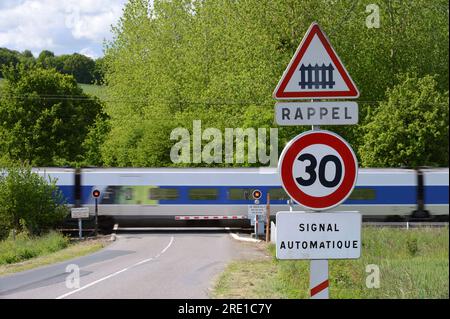 Passage à niveau sur une route de campagne avec portail ferroviaire automatique. Panneau de passage à niveau, limite de vitesse de 30 km/h. Banque D'Images