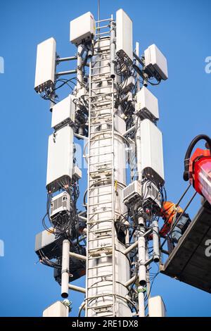 Déploiement de la 5G en France : installation de stations relais de téléphonie mobile avec plateforme aérienne de travail. Techniciens au travail. Téléphone français et Internet pro Banque D'Images