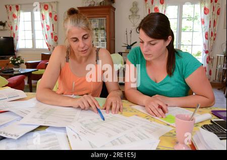Visite d’un comptable agréé à la ferme d’un jeune couple. Expert-comptable et jeune femme diplômée, agricultrice, lecture de documents : plan comptable Banque D'Images