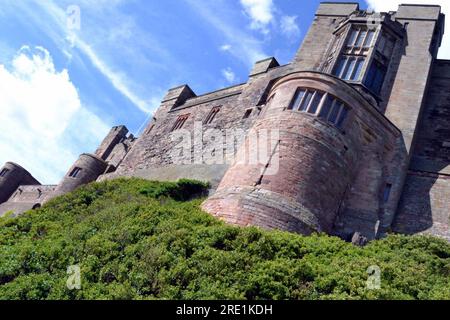 Vue de l'extérieur du château de Bamburgh, un château sur la côte nord-est de l'Angleterre, par le village de Bamburgh dans le Northumberland. C'est un bâtiment classé Grade I. Banque D'Images