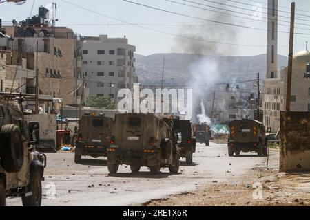 Nalus, Palestine. 24 juillet 2023. Des véhicules militaires israéliens blindés tirant des bombes lacrymogènes sur des Palestiniens lors d’une opération militaire à l’intérieur du camp, à l’est de Naplouse, en Cisjordanie occupée. L ' armée israélienne a attaqué les camps de Nour Shams, à l ' est de Tulkarem, et Aqabat Jabr à Jéricho (Askar), à l ' est de Naplouse, au cours d ' une opération conjointe visant à arrêter les personnes recherchées. (Photo de Nasser Ishtayeh/SOPA Images/Sipa USA) crédit : SIPA USA/Alamy Live News Banque D'Images