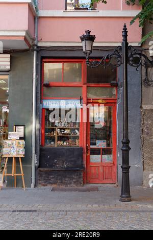 Tiny Vintage Toy Shop extérieur avec porte rouge et cadre et ville de Plovdiv, Bulgarie, 24 juillet 2023. Banque D'Images