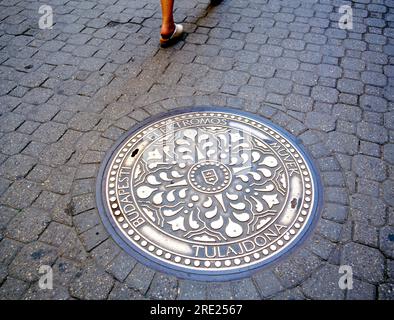 Budapest signe de la ville sur la vieille couverture de trou d'homme dans une rue pavée avec un piéton marchant Banque D'Images