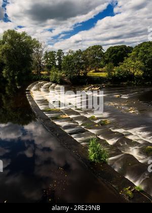 Un beau déversoir sur la rivière Wharfe à Burley-in-wharfedale en Angleterre. Banque D'Images