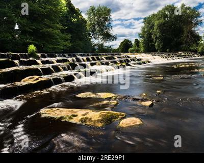 Un beau déversoir sur la rivière Wharfe à Burley-in-wharfedale en Angleterre. Banque D'Images