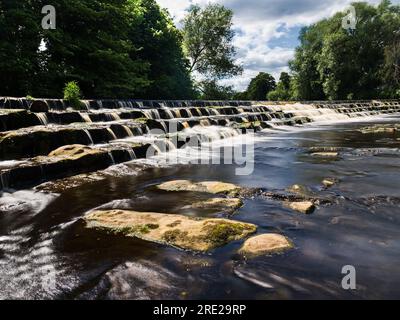 Un beau déversoir sur la rivière Wharfe à Burley-in-wharfedale en Angleterre. Banque D'Images