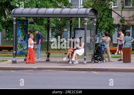 Kazakhstan, Almaty. Scène de rue : passagers attendant le bus à l'arrêt de bus. Banque D'Images