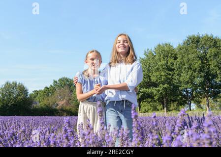 Deux copines adolescentes sur la lavande fleurie. Rire, profiter des vacances d'été Banque D'Images