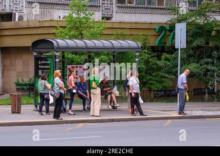 Kazakhstan, Almaty. Scène de rue : passagers attendant le bus à l'arrêt de bus. Banque D'Images