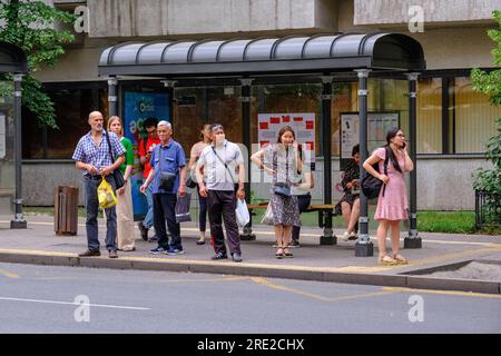 Kazakhstan, Almaty. Scène de rue : passagers attendant le bus à l'arrêt de bus. Banque D'Images