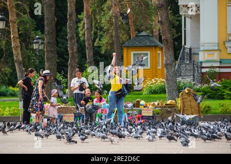 Kazakhstan, Almaty. Les gens achètent des semences pour nourrir les pigeons devant la cathédrale de l'Ascension, Panfilov Guardsmen Park. Banque D'Images