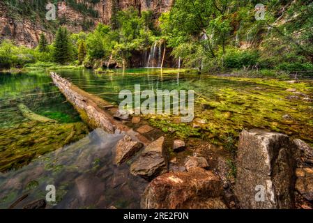 Hanging Lake dans le centre du Colorado, un lac de montagne isolé avec un arbre tombé en perspective profonde avec un fond de cascade. Banque D'Images