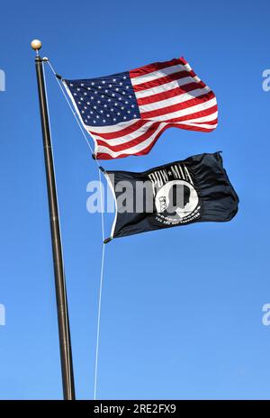 Willard, Missouri - 21 février 2016 : le drapeau américain avec le drapeau MIA de prisonnier volant contre un ciel bleu. Le drapeau POW MIA est un symbole de l'armée américaine Banque D'Images