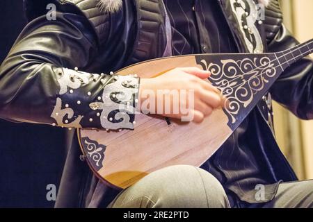 Kazakhstan, Almaty. Jeune musicien jouant de la Dombra, un instrument à cordes traditionnel kazakh trouvé parmi les peuples turcs d'Asie centrale. Banque D'Images