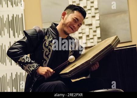 Kazakhstan, Almaty. Jeune musicien jouant du Dabyl, un tambour kazakh. Banque D'Images