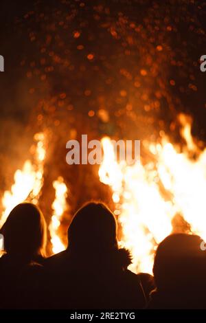 Les gens se tiennent autour d'un feu de joie sur Guy Fawkes Night en Angleterre, Royaume-Uni Banque D'Images