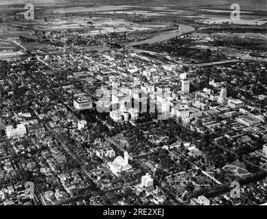 Sacramento, Californie, le 12 avril 1933 vue aérienne du Capitole de l'État de Californie entre les bâtiments Capitol Park et Capitol extension, les sections commerciales et industrielles et la rivière Sacramento. Banque D'Images