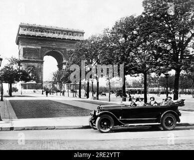Paris, France : c. 1929 personnes dans une voiture de tourisme à l'Arc de Triomphe de l'Etoile à l'extrémité ouest des champs-Elysées à Paris. Banque D'Images
