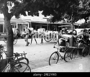 Nassau, Bahamas : 8 novembre 1943 Une scène de rue à Nassau avec des chariots tirés par des chevaux, des vélos et des voitures. Banque D'Images