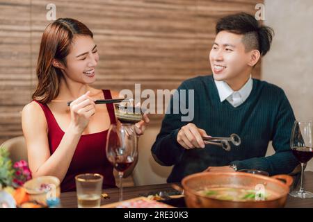 Heureux couple dînant dans le restaurant Hotpots Banque D'Images