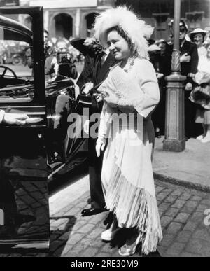 Londres, Angleterre : 29 juillet 1950 la reine Elizabeth quitte un service commémoratif à l'abbaye de Westminster pour les policiers métropolitains tués pendant les deux guerres mondiales. Elle porte un chapeau à plumes d'autruche, un chapelet de perles, une robe à franges de soie et des chaussures plates-formes. Banque D'Images