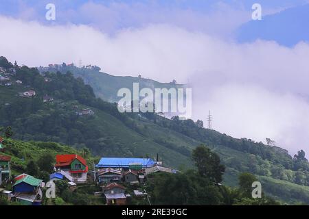 vue panoramique du village de montagne brumeux et nuageux entouré par la forêt verte en saison de mousson, près de la station de montagne darjeeling dans l'ouest du bengale en inde Banque D'Images