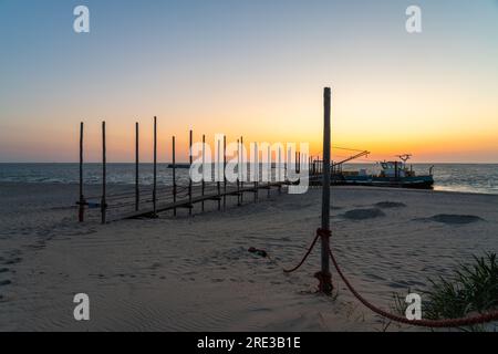 Au lever du soleil, cette belle jetée en bois se dresse sur la plage dans la mer Banque D'Images