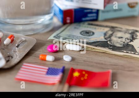 Une compétition pharmaceutique, médicale, conflit, concept avec les drapeaux américain et chinois et divers médicaments sur un bureau. Banque D'Images