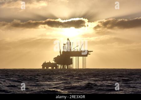 Silhouette d'une plate-forme de forage Jack up dans la mer du Nord au coucher du soleil. Banque D'Images